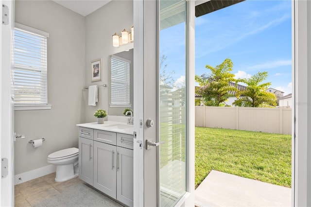 bathroom featuring plenty of natural light, vanity, toilet, and tile patterned floors