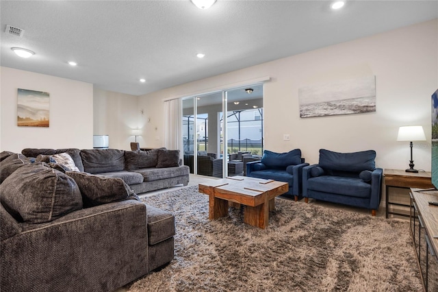 living room with visible vents, wood finished floors, a textured ceiling, and recessed lighting