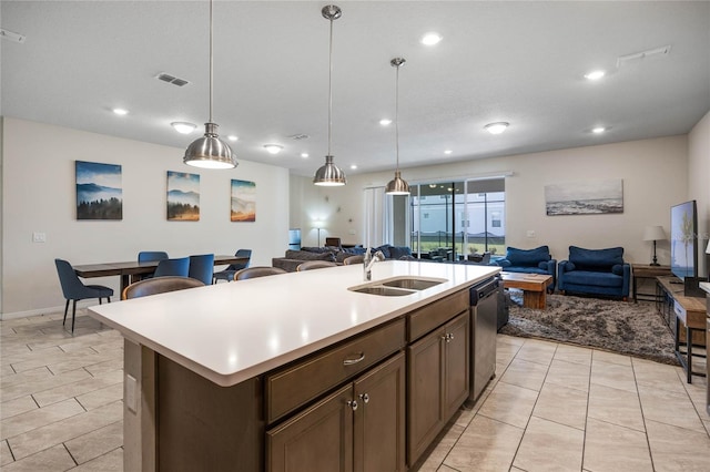 kitchen featuring light countertops, visible vents, open floor plan, a sink, and dishwasher