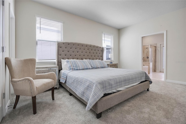 bedroom featuring light carpet, connected bathroom, and baseboards