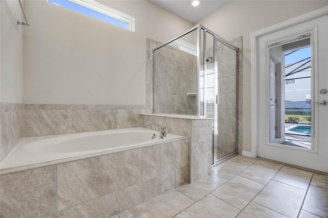 bathroom with a garden tub, a shower stall, and tile patterned floors