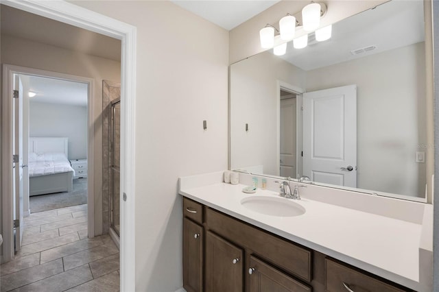 ensuite bathroom featuring ensuite bathroom, vanity, a shower stall, and visible vents