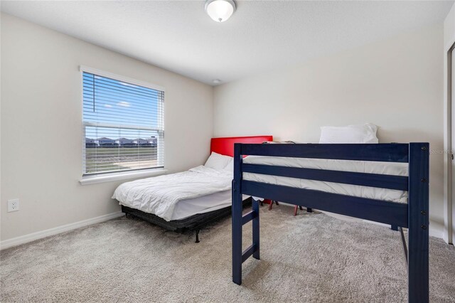 bedroom featuring carpet floors and baseboards