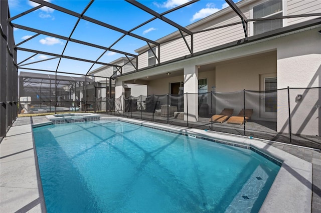 view of swimming pool featuring a patio, a pool with connected hot tub, and glass enclosure