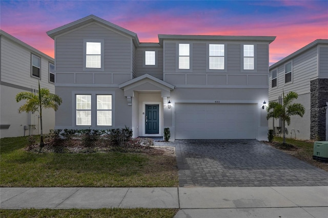 view of front of property featuring an attached garage, decorative driveway, and stucco siding