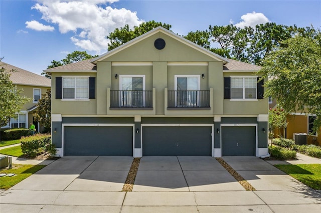 view of front of home featuring a garage, central AC unit, and stucco siding