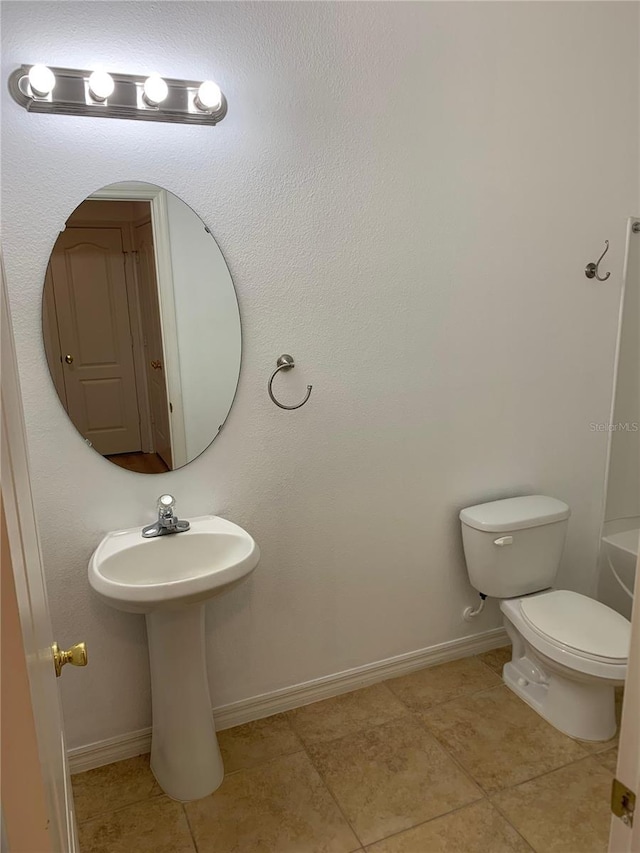 full bath with a tub, tile patterned flooring, baseboards, and toilet