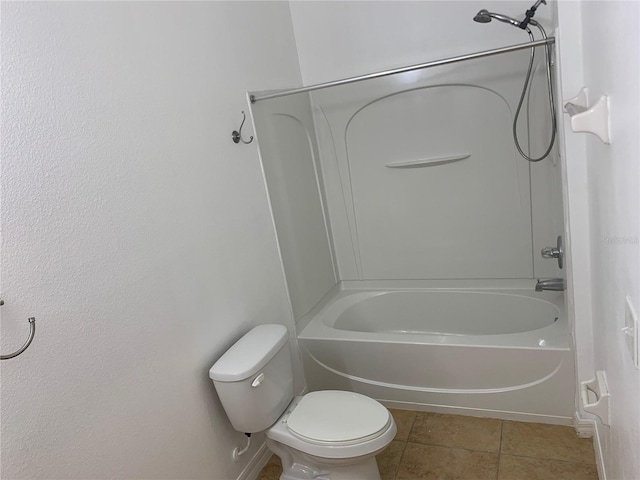 bathroom featuring bathing tub / shower combination, tile patterned flooring, toilet, and baseboards