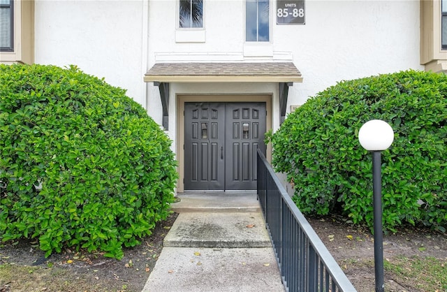 doorway to property featuring stucco siding