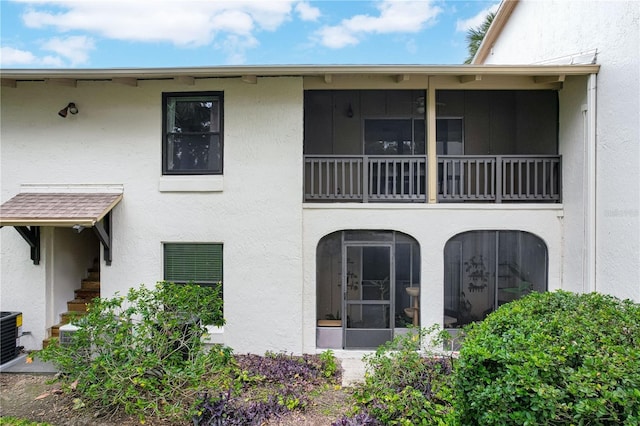 exterior space featuring a sunroom and stucco siding