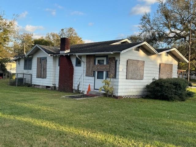 view of front of home featuring crawl space, a chimney, and a front yard