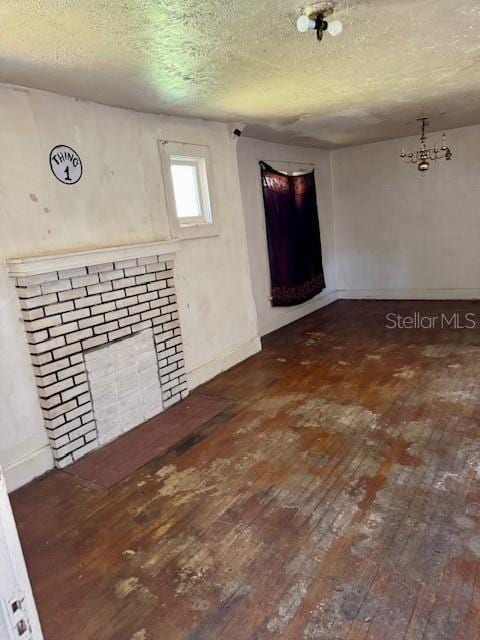 interior space with baseboards, a textured ceiling, and hardwood / wood-style floors