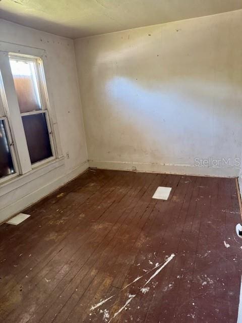 unfurnished room with hardwood / wood-style floors and baseboards