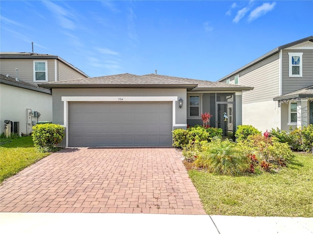 view of front of house featuring a garage, decorative driveway, and stucco siding