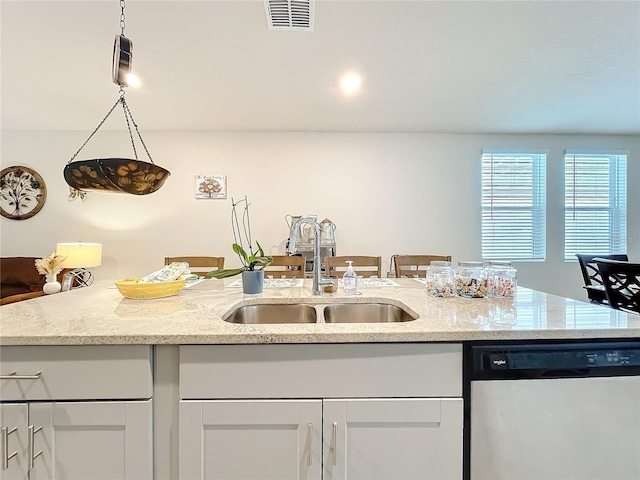 kitchen with visible vents, dishwasher, a sink, and light stone countertops