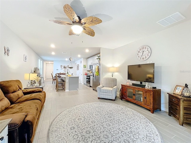 living room featuring light wood-style flooring, recessed lighting, visible vents, and a ceiling fan