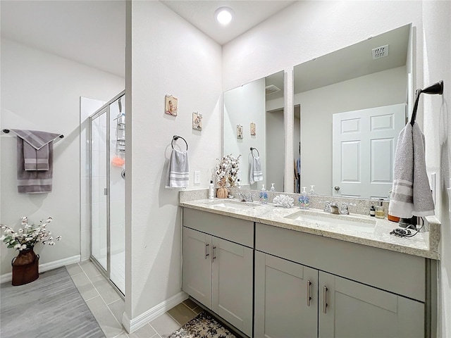 full bath with a stall shower, visible vents, a sink, and double vanity