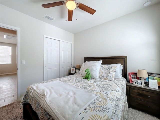 carpeted bedroom with a ceiling fan, visible vents, and a closet