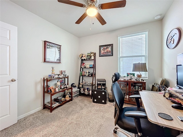 carpeted office featuring a ceiling fan and baseboards