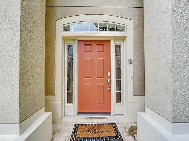 entrance to property featuring stucco siding