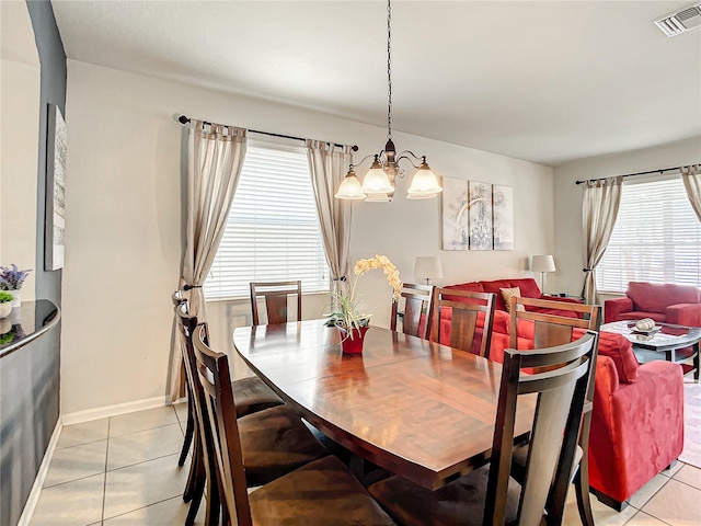 dining room featuring light tile patterned floors, a chandelier, visible vents, and baseboards