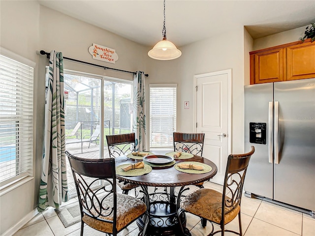 dining space featuring light tile patterned floors and baseboards