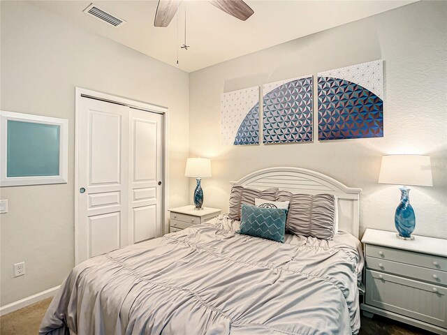 bedroom with a ceiling fan, visible vents, baseboards, a closet, and dark colored carpet