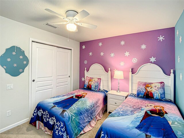 bedroom featuring light colored carpet, a ceiling fan, baseboards, visible vents, and a closet