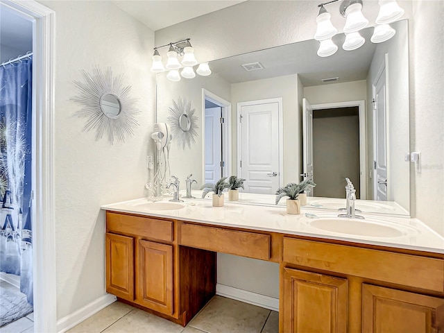 bathroom with a sink, double vanity, tile patterned flooring, and visible vents