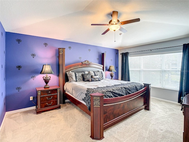 bedroom featuring ceiling fan, baseboards, vaulted ceiling, and light colored carpet