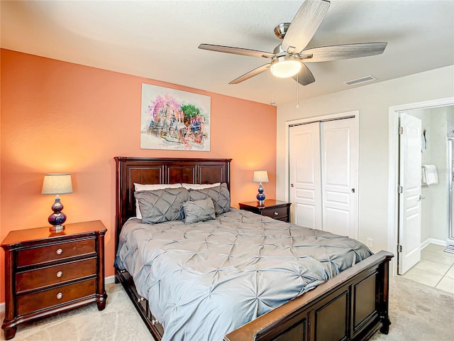 bedroom featuring ceiling fan, light carpet, visible vents, a closet, and ensuite bath