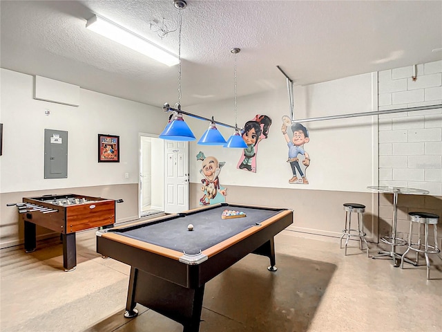 game room featuring finished concrete flooring, pool table, a textured ceiling, and electric panel