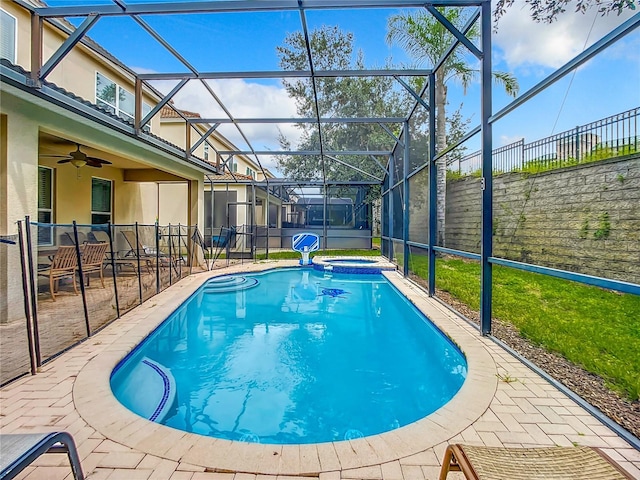 view of swimming pool featuring a ceiling fan, a patio, a lanai, fence, and a pool with connected hot tub