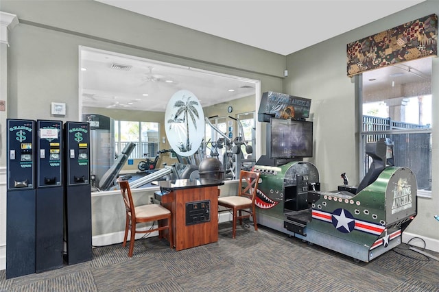 exercise room featuring baseboards, carpet flooring, visible vents, and a ceiling fan