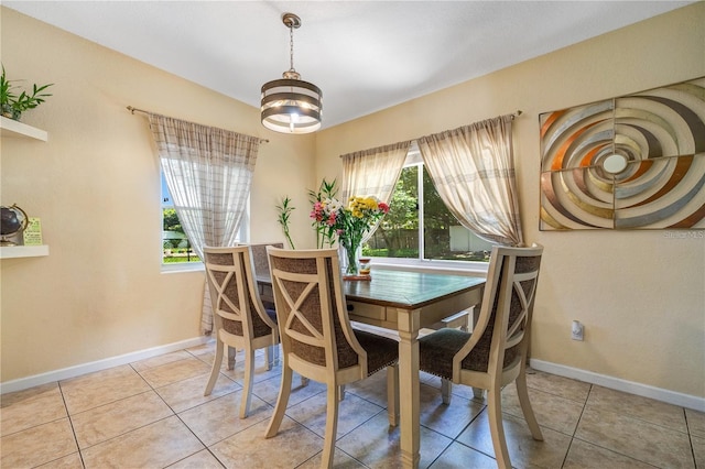 dining area with light tile patterned floors, baseboards, plenty of natural light, and a chandelier