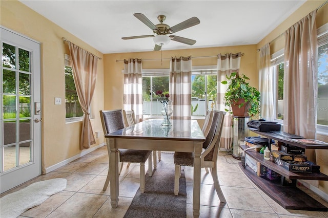 dining room with plenty of natural light, light tile patterned flooring, baseboards, and ceiling fan