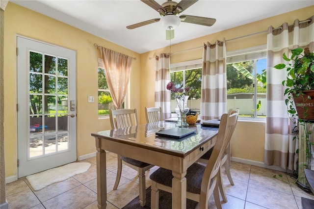 dining area featuring light tile patterned floors, baseboards, and ceiling fan