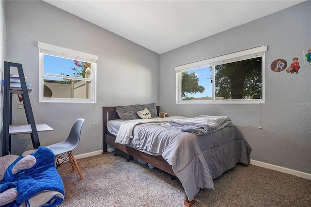 carpeted bedroom featuring lofted ceiling, a textured wall, and baseboards