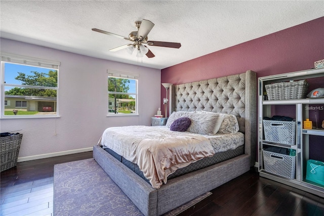 bedroom featuring baseboards, wood-type flooring, a textured ceiling, and ceiling fan