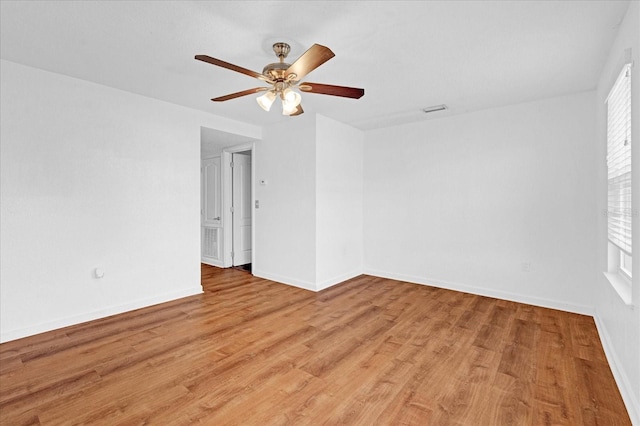 empty room featuring visible vents, baseboards, light wood-type flooring, and ceiling fan