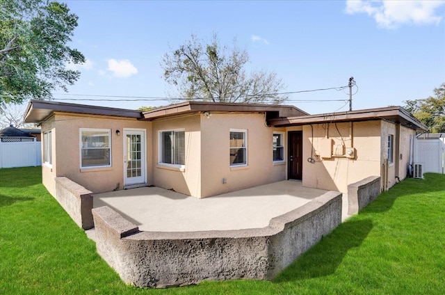 back of property featuring a patio area, stucco siding, a lawn, and fence