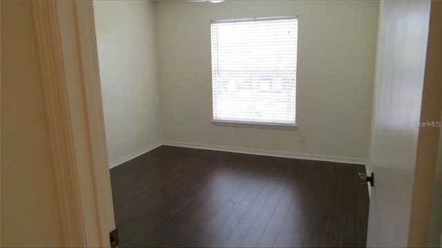 unfurnished room featuring dark wood finished floors and baseboards