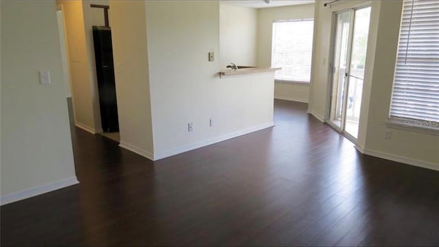 empty room with dark wood finished floors and baseboards