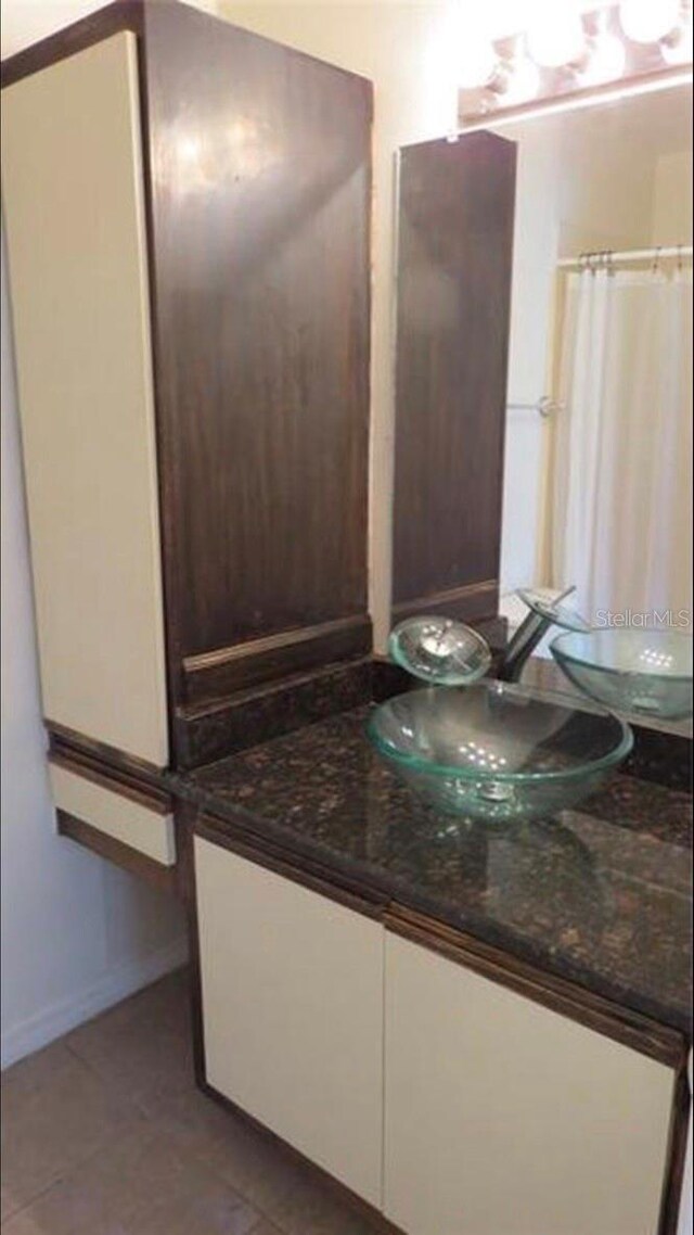 full bathroom featuring curtained shower, tile patterned flooring, baseboards, and vanity