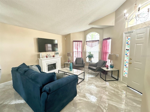 living area featuring vaulted ceiling, marble finish floor, a fireplace, and a chandelier