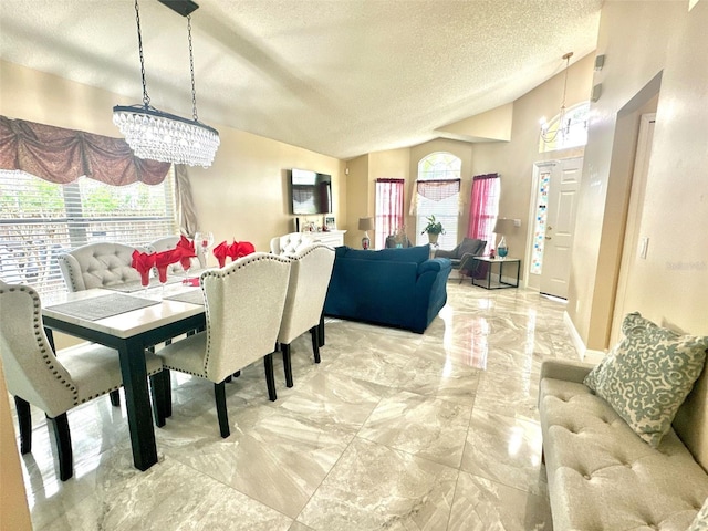 dining area featuring vaulted ceiling, marble finish floor, a textured ceiling, and a chandelier