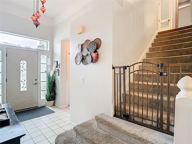 entryway with stairway, baseboards, and tile patterned flooring