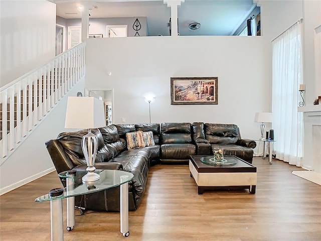 living room with a high ceiling, wood finished floors, and stairs