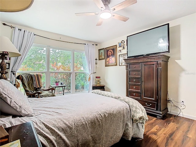 bedroom featuring dark wood-type flooring, a ceiling fan, and baseboards