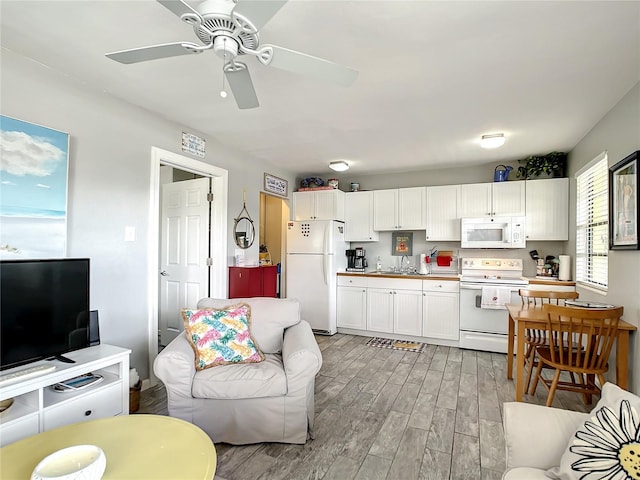 living area with a ceiling fan and light wood-style floors